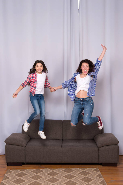 happy sisters jump in freedom sense. mother and daughter having fun on weekend. move in new house. full of energy. real happiness. happy family day. girls party at home. Everyones dream - Photo, image