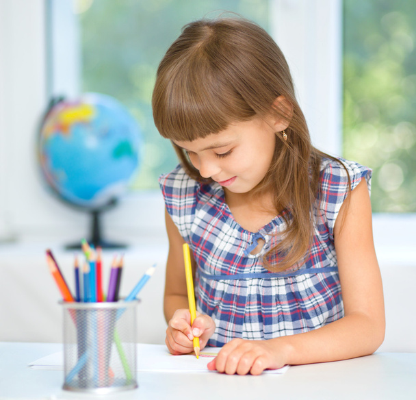 Little girl is drawing using pencils - 写真・画像
