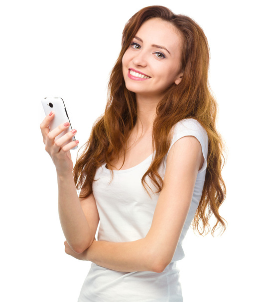 Young woman is typing sms message on her phone - Foto, imagen