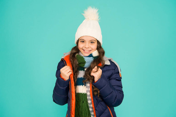 Kid wear hat and jacket blue background. Winter sports. Feeling comfy. Cold season shopping. Child in padded warm coat. Seasonal fashion. Winter holidays. Fashion girl winter clothes. Fashion trend - Foto, immagini