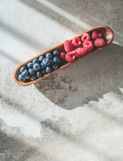 Blueberry and raspberry in bowl on gray table, topview - Photo, Image