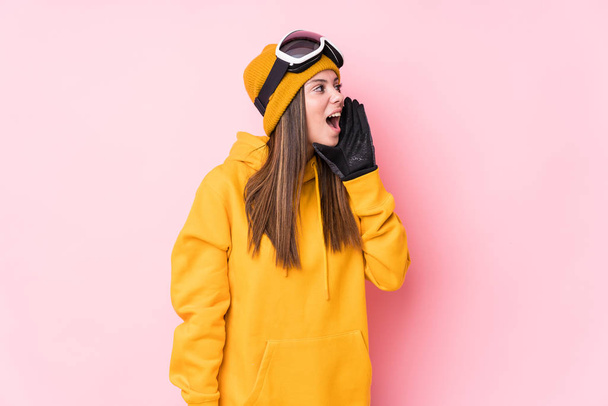 Young caucasian skier woman isolated shouting and holding palm near opened mouth. - Φωτογραφία, εικόνα