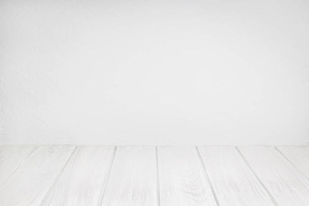 Prázdný dřevěný stůl na bíle omyté texturované zdi - Fotografie, Obrázek
