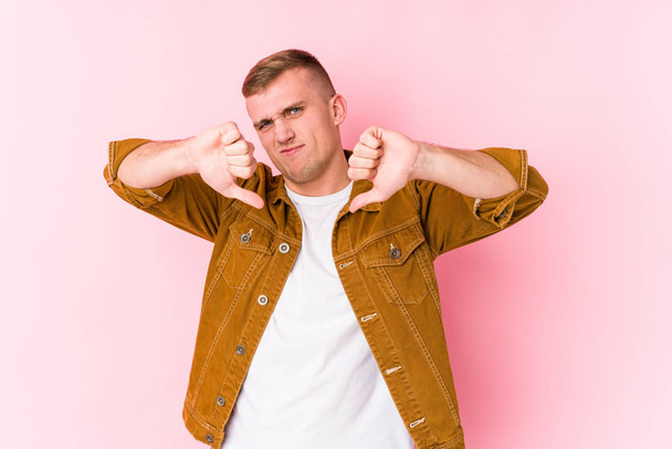 Young caucasian man isolated showing thumb down and expressing dislike. - Photo, Image