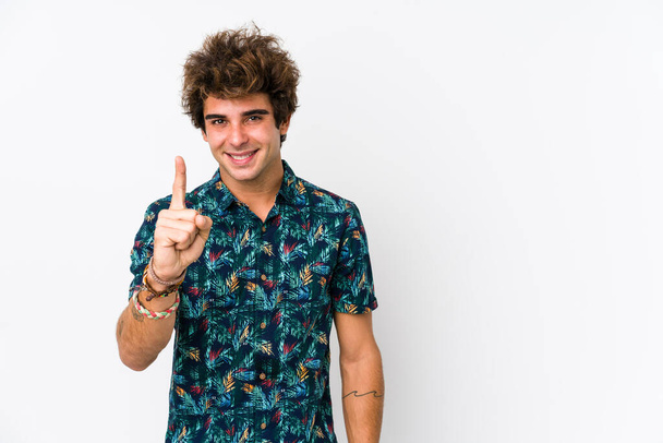 Mladý kavkazský muž v květinovém tričku izolovaný ukazující číslo jedna s prstem. - Fotografie, Obrázek