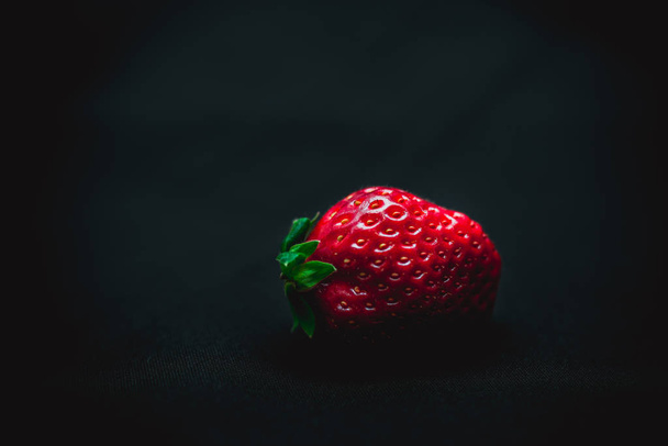 large strawberries on a black background - Foto, afbeelding