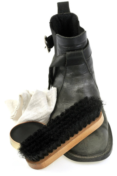 Zapatos de cuero junto a una caja de pulido de zapatos, un cepillo y un primer plano de tela sobre un fondo blanco
 - Foto, Imagen