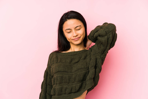 Young chinese woman isolated on a pink background suffering neck pain due to sedentary lifestyle. - Photo, image