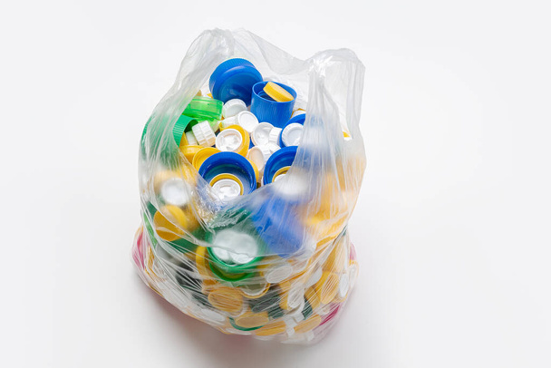 мешок полный пластиковых крышек готовы к переработке
 - Фото, изображение