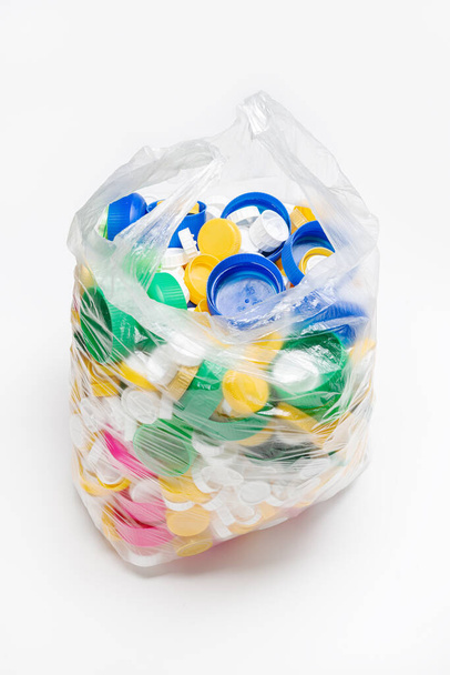 bolsa llena de tapas de plástico listas para ser recicladas
 - Foto, imagen