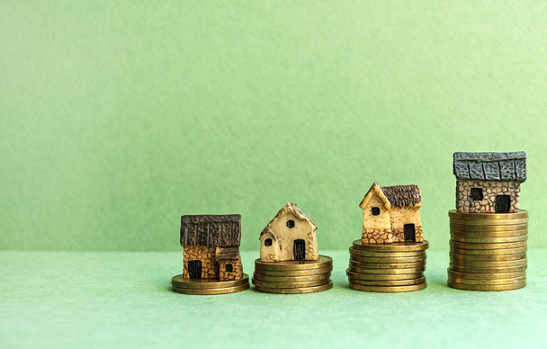 Hypotéka koncept malé dekorativní domy procentuální měřítko z mincí. Koncepční schodiště, hypoteční a realitní investice. Na světle zelemon pozadí.  - Fotografie, Obrázek