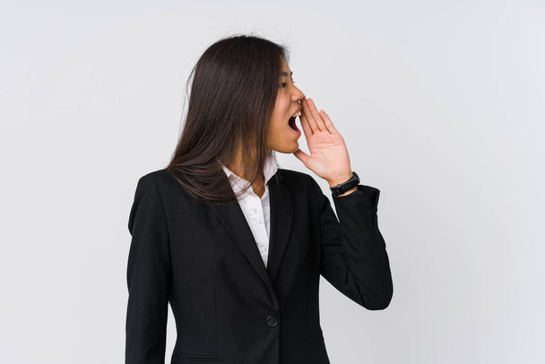 Giovane donna d'affari asiatica urlando e tenendo la palma vicino alla bocca aperta
. - Foto, immagini