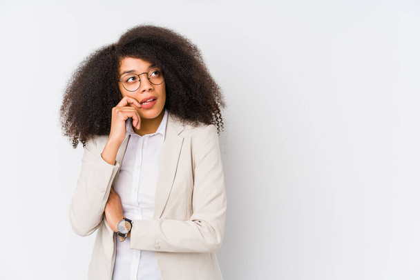 Νεαρή αφροαμερικανίδα επιχειρηματίας χαλαρός σκέφτεται κάτι κοιτάζοντας ένα χώρο αντίγραφο. - Φωτογραφία, εικόνα