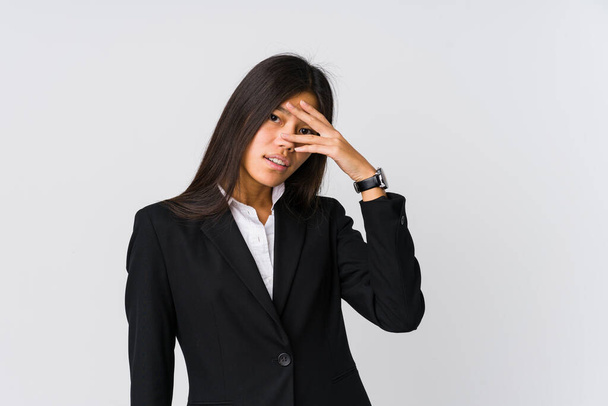 młody Azji biznes kobieta mrugnąć w w aparat przez palce wstyd pokrycie twarz. - Zdjęcie, obraz