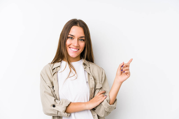 Young caucasian woman  isolated smiling cheerfully pointing with forefinger away. - Photo, image