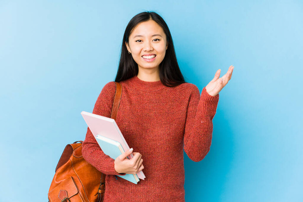 Fiatal kínai diák nő elszigetelt fogadó kellemes meglepetés, izgatott és felemeli a kezét. - Fotó, kép