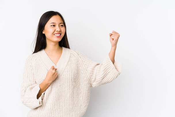 Young chinese woman isolated raising fist after a victory, winner concept. - 写真・画像