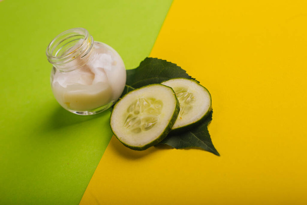 Crema de pepino blanco sobre un fondo amarillo-verde. Con hojas y pepino fresco
 - Foto, imagen