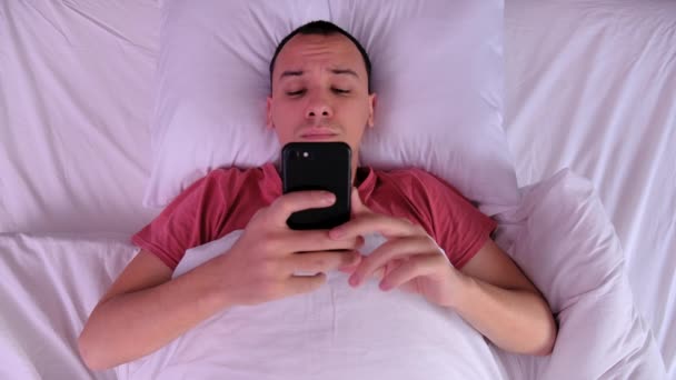 Top view man waking up and using her smartphone - Video, Çekim