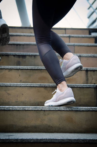 Κοντινό πλάνο σε αθλητή παπουτσιών, γυναίκα τρέχει στην πόλη. Έννοια αθλητισμού - Φωτογραφία, εικόνα