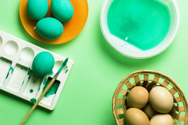 Colored easter eggs with feathers on a green background. Monochrome. Top view. - Фото, зображення
