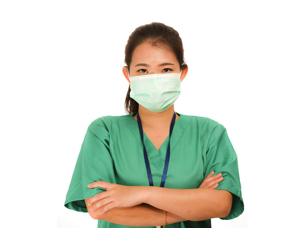 confident Asian Korean medicine doctor woman or hospital nurse in green scrubs and surgical protective face mask in protection against virus outbreak concept - Foto, Bild