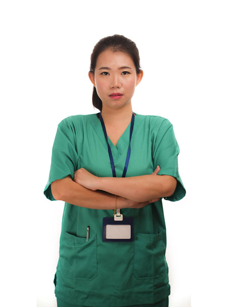 young beautiful and confident Asian Chinese medicine doctor woman or hospital nurse in green scrubs posing serious  in corporate clinic staff portrait on isolated - Фото, зображення