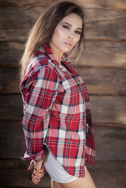 Portrait of beautiful young girl on wooden background. - 写真・画像