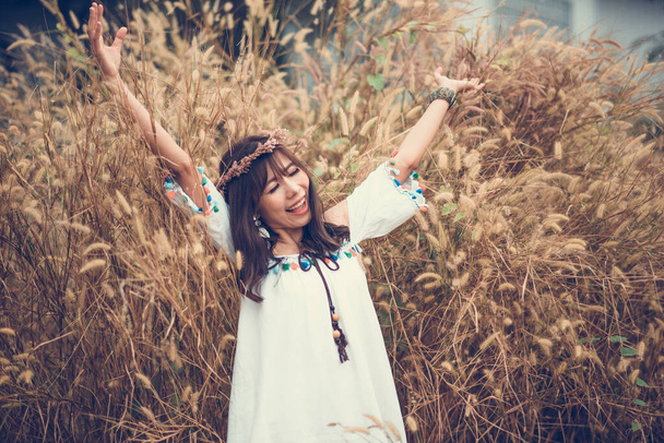 Een portret van een Aziatisch mooi hippie meisje in witte jurk op een  - Foto, afbeelding