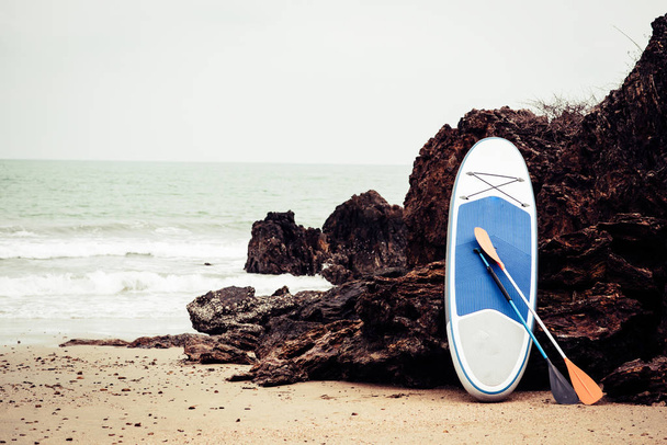 Surfboard On Rock At Beach Against Clear Sky - Photo, image