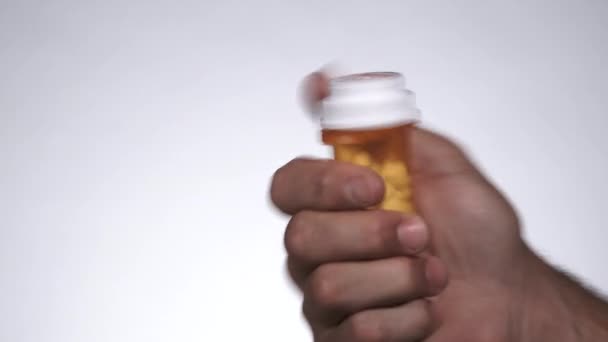 Detailní záběr osoby odšroubování lék kontejner a vysypání všech pilulek pak ponechání rám ve studiu. - Záběry, video