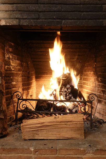 fire burning in old fireplace with charred bricks - 写真・画像