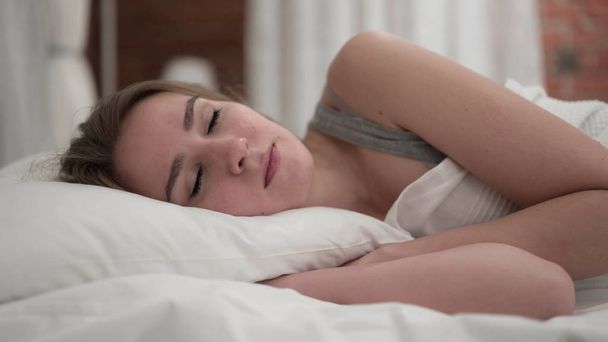 Atractiva joven mujer despertando y dejando la cama
 - Foto, imagen