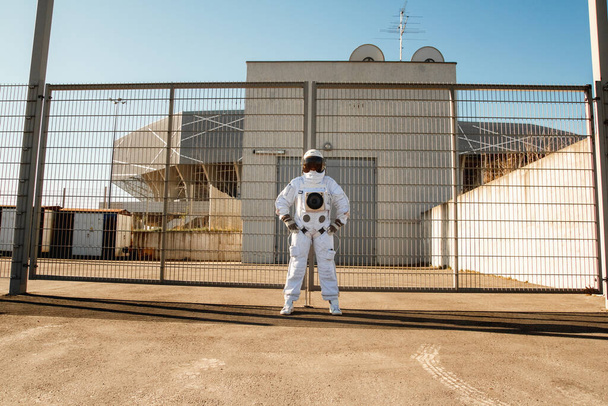 Astronauta na futurystycznym tle miasta, spojrzenie w przyszłość. Fantastyczny kosmiczny kostium. - Zdjęcie, obraz
