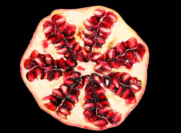 Pomegranate fruit cut in half on a black background - Фото, зображення
