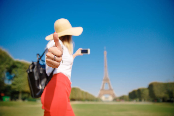 Młoda studentka z plecakiem fotografuje wieżę Eiffla latem. Koncepcja uczenia się na wymianie uniwersyteckiej - Zdjęcie, obraz