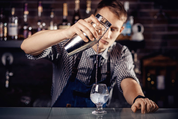 Barman prépare un cocktail dans un shaker avec de l'alcool et de la glace. Fond sombre Barman
 - Photo, image