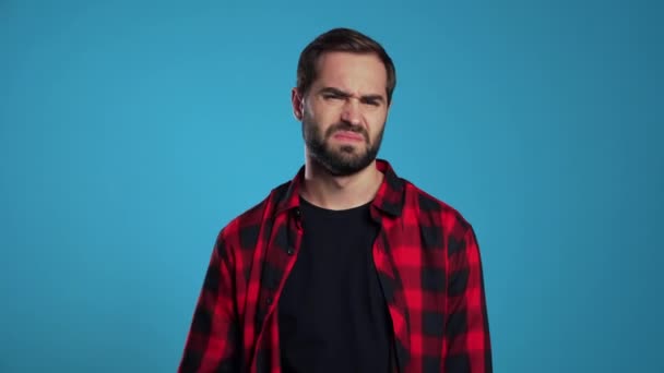 Young guy covers his face with hand from fatal disappointment, failure. Depressed lost man in red plaid shirt. Drama, emotions concept.  - Imágenes, Vídeo