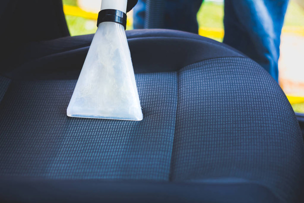 Der Mensch macht Autopolsterreinigung - professionelle chemische Reinigung mit Saugmethode. Hygienische Arbeiten und Fleckentfernung auf dem Fahrzeugsitz - Foto, Bild