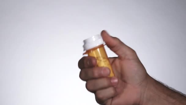 In de studio, persoon opent pil container en dumpt alle medicijnen en gooit het dan weg. - Video