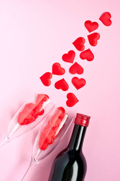 Valentijnsdag concept. Wijnfles en glazen op kleur achtergrond - Foto, afbeelding