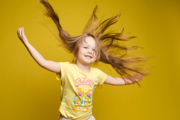 Fille aux cheveux longs en chemise mignonne jouant avec les cheveux et tournoyant
 - Photo, image