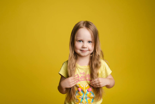 Criança caucasiana adorável com cabelos longos sorrindo para a câmera
. - Foto, Imagem