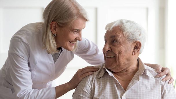 Позитивная медсестра, ухаживающая за пациентом старшего возраста
 - Фото, изображение