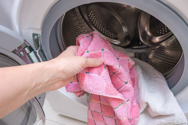 Woman housewife pull the laundry out of or load a washing machine - Zdjęcie, obraz