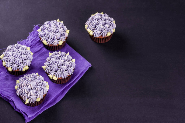 Delicados cupcakes de chocolate close-up em uma mesa escura com um guardanapo
. - Foto, Imagem