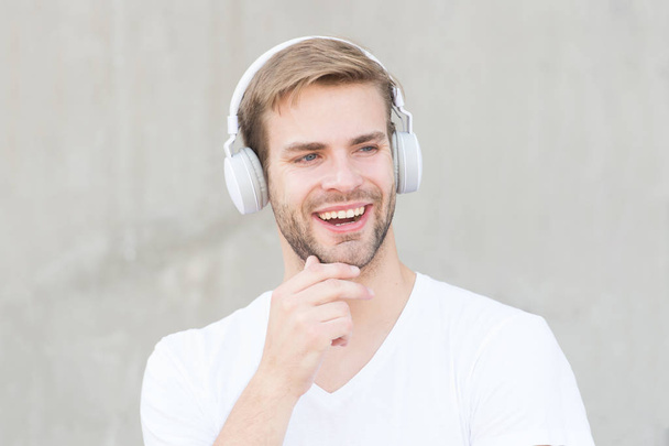 Noise Reduction. Wireless Earpiece. Handsome guy wear headphones grey background. Man listen modern music. Modern technology. Modern and contemporary music. Hobby leisure. Foldable Stereo Headphones - Photo, image