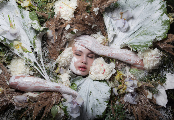Female portrait in fairy tale stylisation surrounded with natural plants and flowers. - Foto, immagini