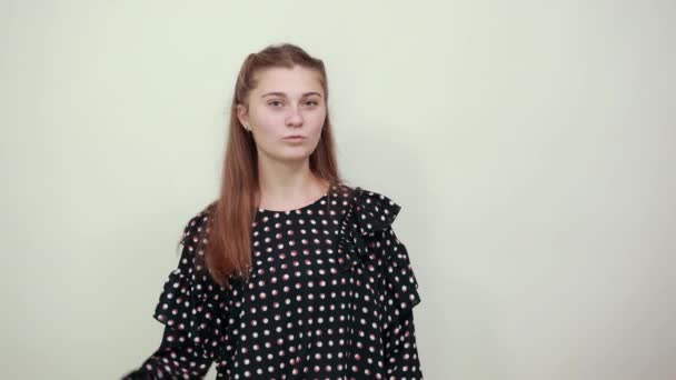 meisje in een zwarte jurk met witte cirkels negatieve stemming geplaatst duimen naar beneden - Video