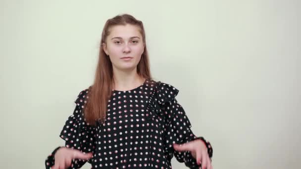 menina em vestido preto com círculos brancos surpreso segura as mãos para enfrentar
 - Filmagem, Vídeo